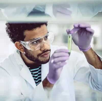 DuPont innovates operations using Machine Health through a man in a lab coat examining a test tube.