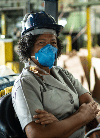 A woman wearing a face mask in a factory is committed to health and safety.