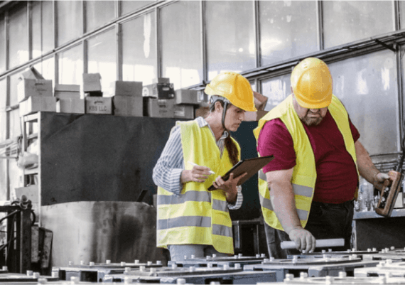 Two people in hard hats working in a factory utilizing Microsoft Azure for automation.