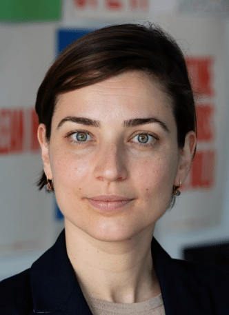 A woman in a blazer standing in front of a wall - Anna Farberov, General Manager, PepsiCo Labs.