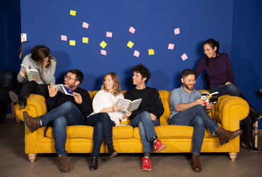 A group sitting on a yellow couch.