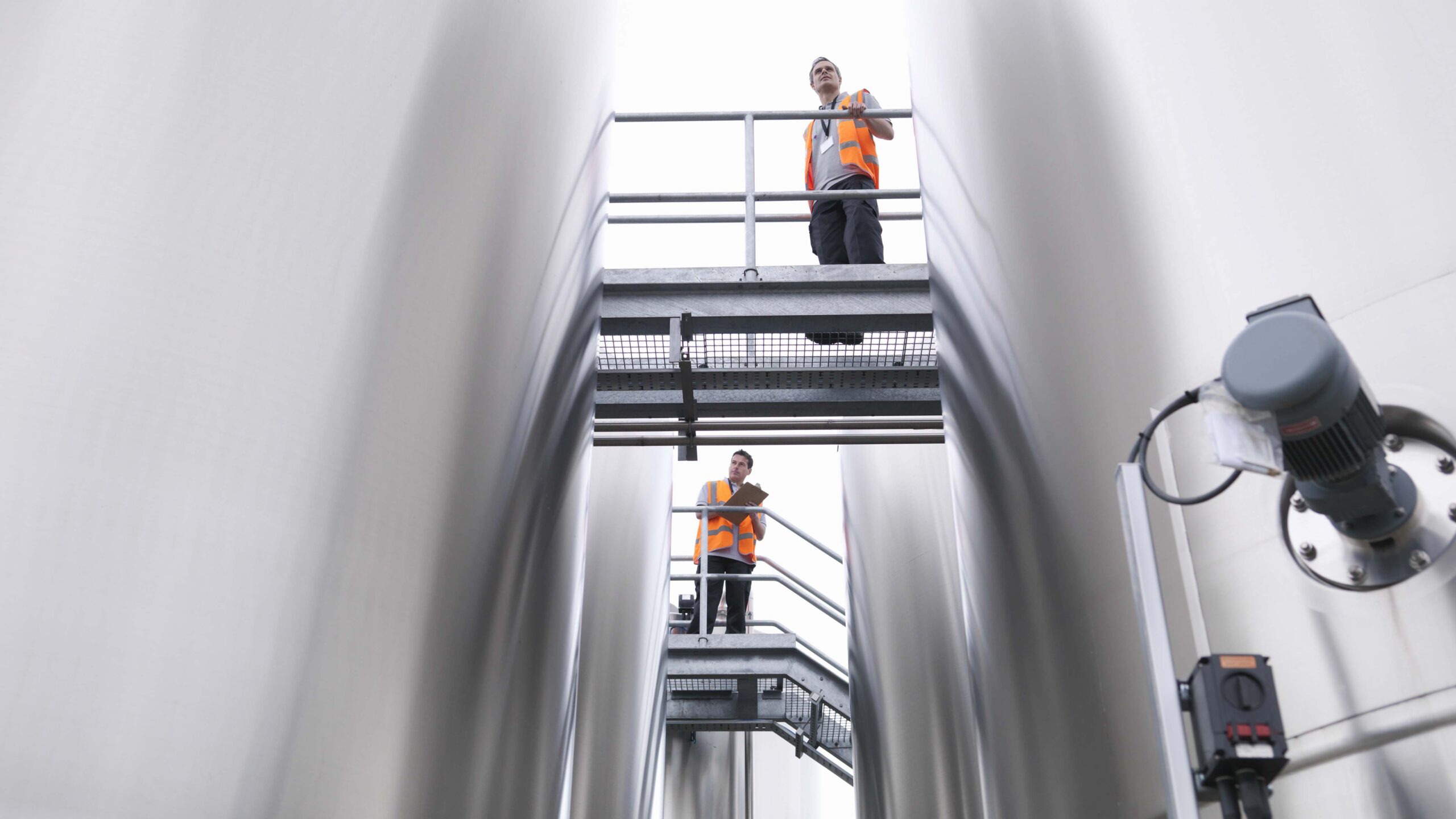 Workers checking tanks in bottling plant