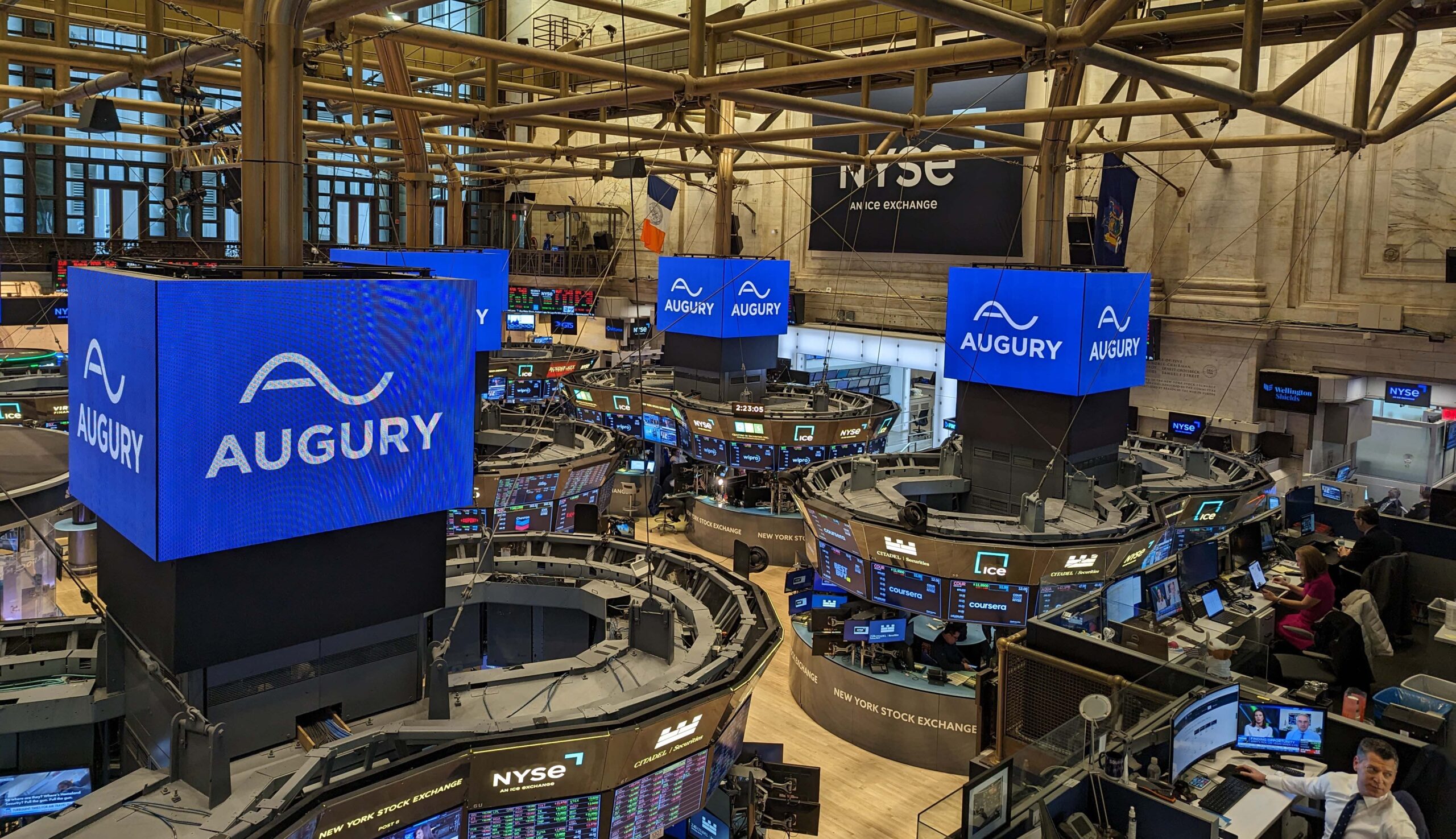 New York Stock Exchange with the Augury logo on all the large screens. 