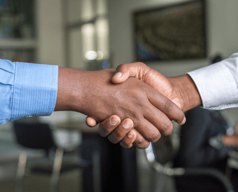Two men shaking hands in a Microsoft office.