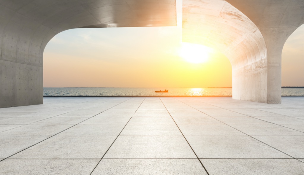 Sun rising behind a beautiful cement construction.