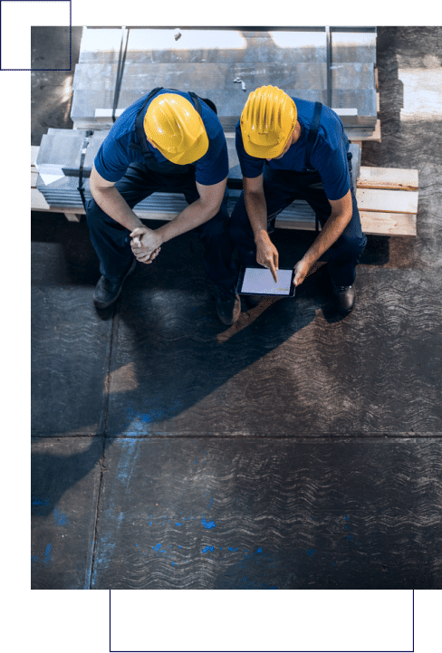 Two construction workers utilizing prescriptive analytics on a roof.