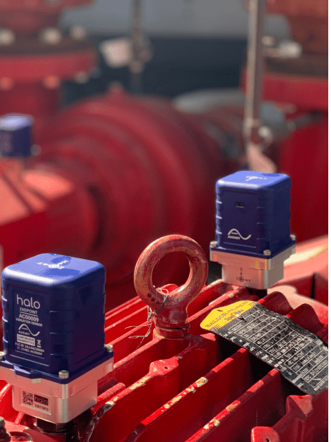 A group of valves on a red pipe, supporting machine health.