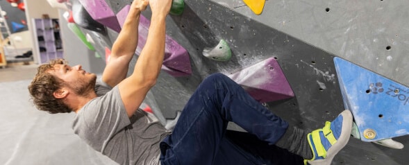 A climber ascending a climbing wall.