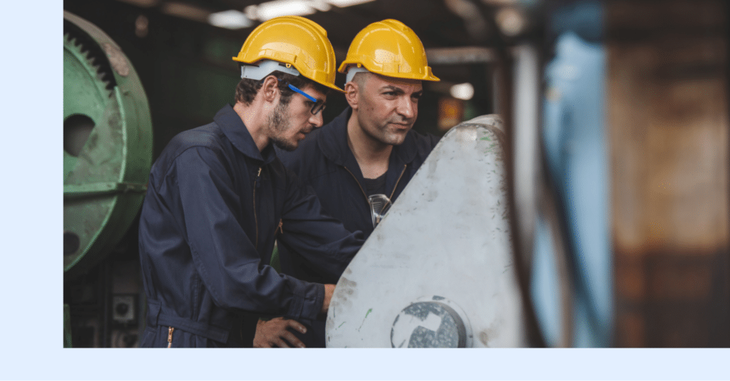 Two maintenance technicians inspecting rotating equipment on an industrial plant floor.