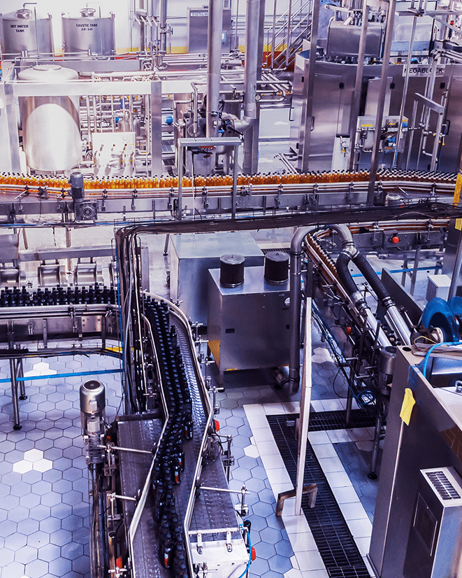 A modern beverage bottling plant with automated conveyor belts carrying bottles, stainless steel tanks, machinery, and hexagonal tiled flooring, showcasing an efficient industrial production line.