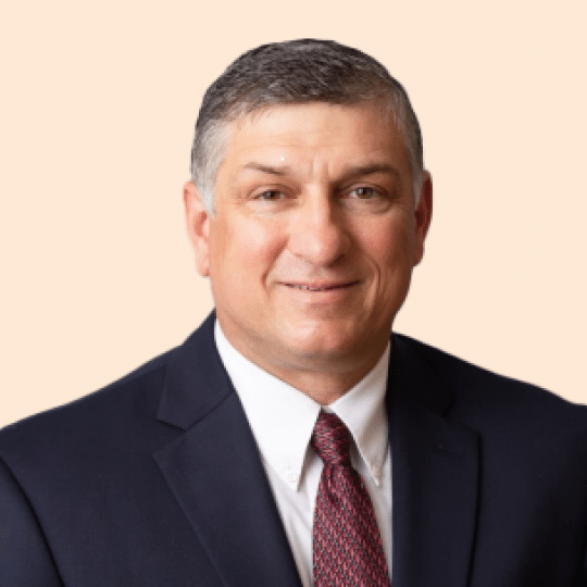 Terry LeDoux, a man in a suit and tie, is posing for a photo.