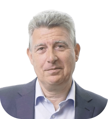 A middle-aged man with gray hair, wearing a dark suit jacket and a light blue shirt, poses against a plain white background.