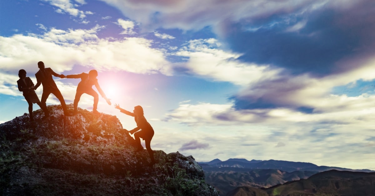 People climbing a mountain together.