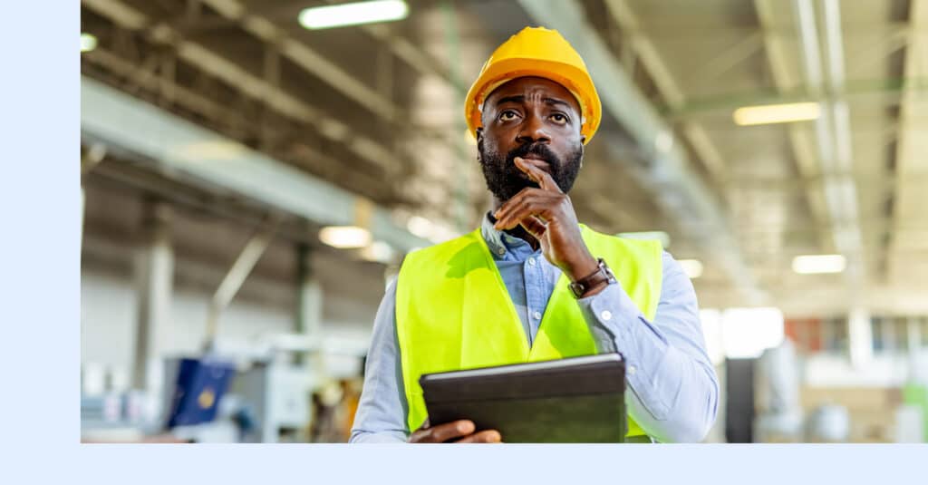 A reliability expert using predictive maintenance analytics to inspect critical assets on the plant floor.