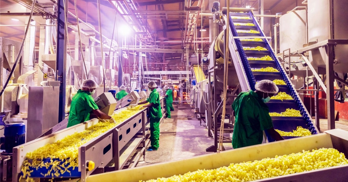 Factory workers do quality control on a snack line.